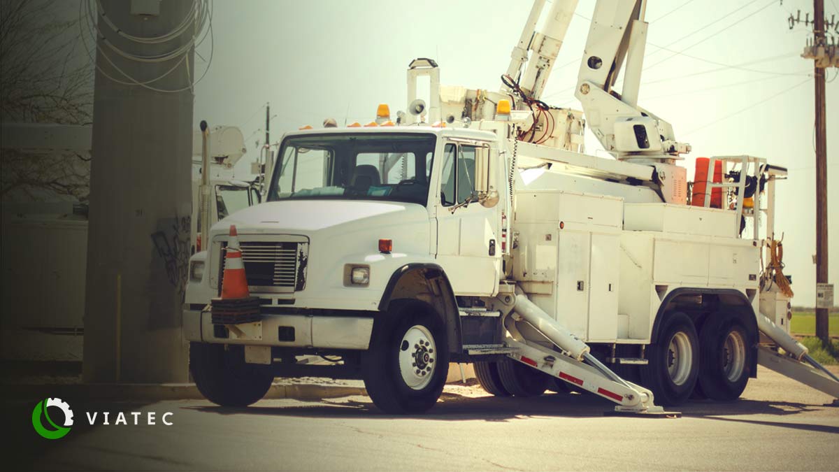 Bucket truck on a road outfitted with a Viatec SmartPTO which reduces fleet management costs, backdropped with a blue sky